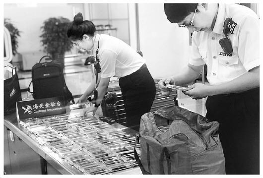 图为海关工作人员在检查旅客携带的假睫毛。王咏洁 摄